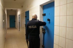 Policjant zamykający drzwi do celi