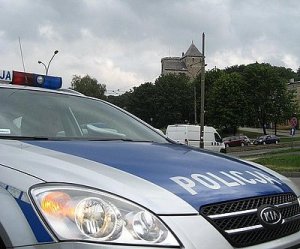Policyjny radiowóz na tle będzińskiego zamku