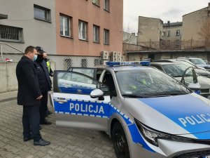 Komandant Powiatowy Policji w Będzinie wraz ze Starostą Powiatu Będzińskiego zaglądają do radiowozu