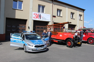 Starosta Będziński Sebastian Szaleniec stojący przy radiowozie z policjantką ruchu drogowego.