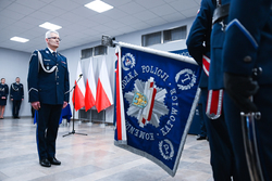 Zdjęcie przedstawiające nowego Komendanta Wojewódzkiego Policji w Łodzi, który stoi przed sztandarem.