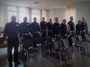 Zdjęcie grupowe policjantów na sali konferencyjnej.