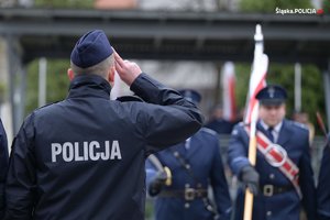 Na zdjęciu salutujący policjant przed sztandarem Komendy Wojewódzkiej Policji w Katowicach.