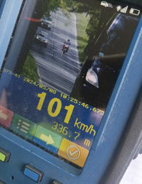 Zdjęcie  policyjnego miernika predkosci na którym widać motocykl przekraczający dozwoloną prędkość.